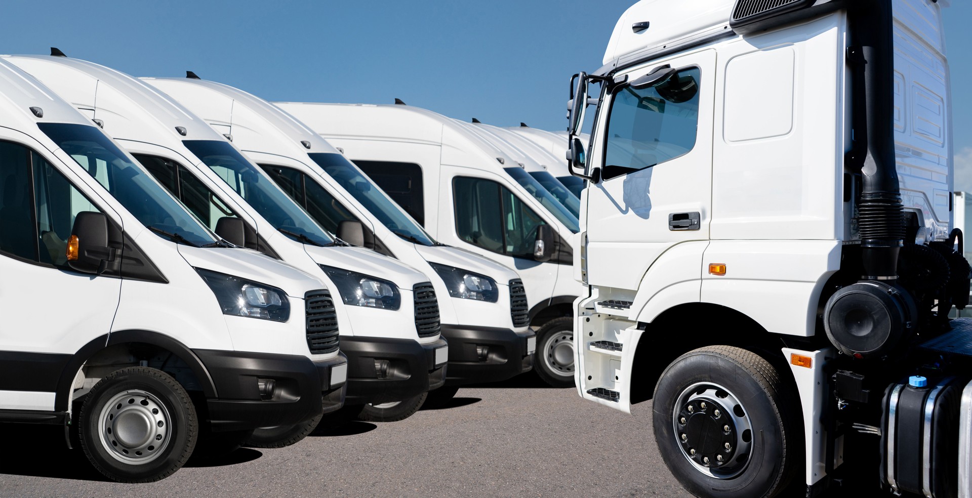 Semi truck and delivery vans  fleet at the logistics center. A lot of trucks parked in a row.