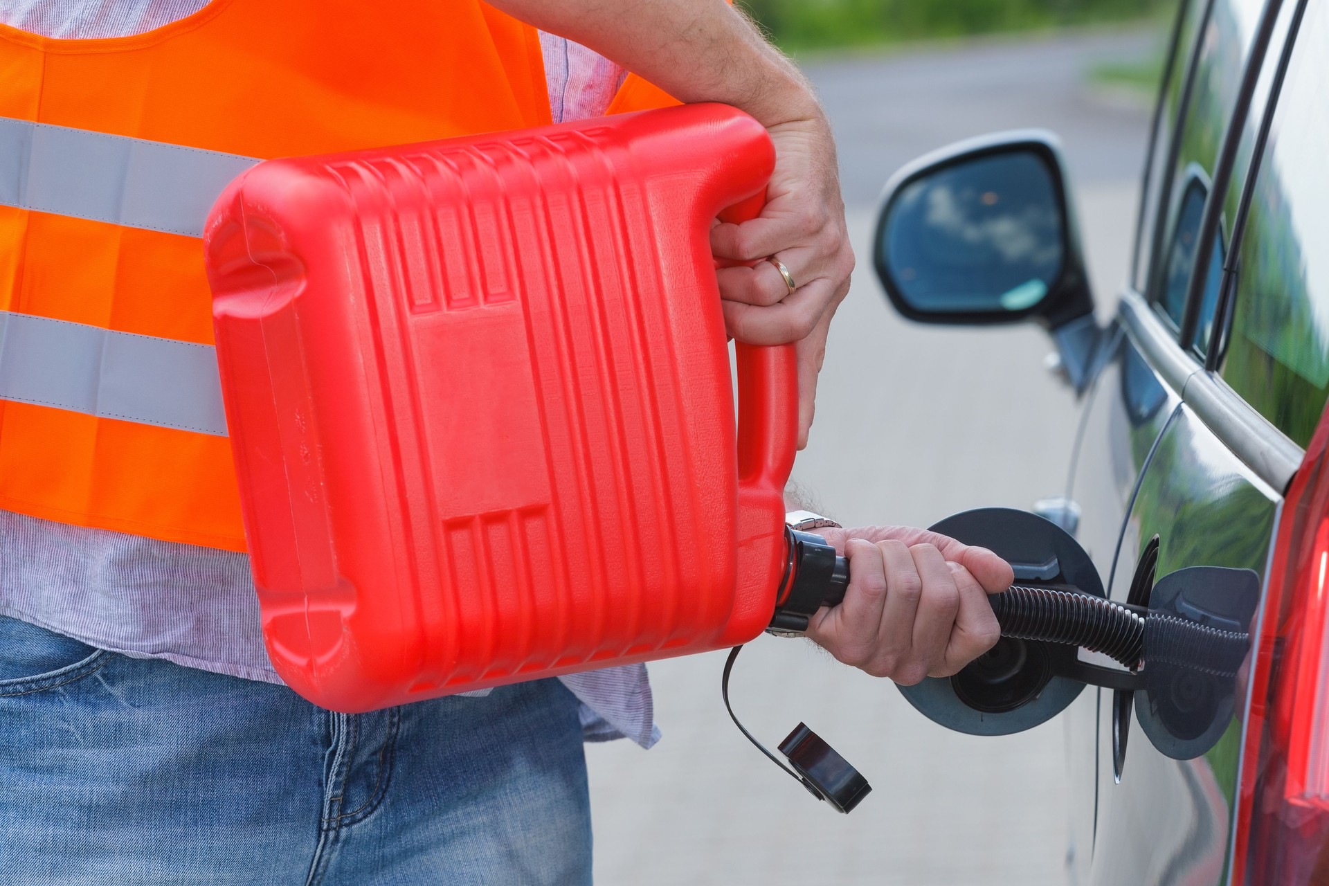 Driver fills the fuel in an empty car tank from canister.